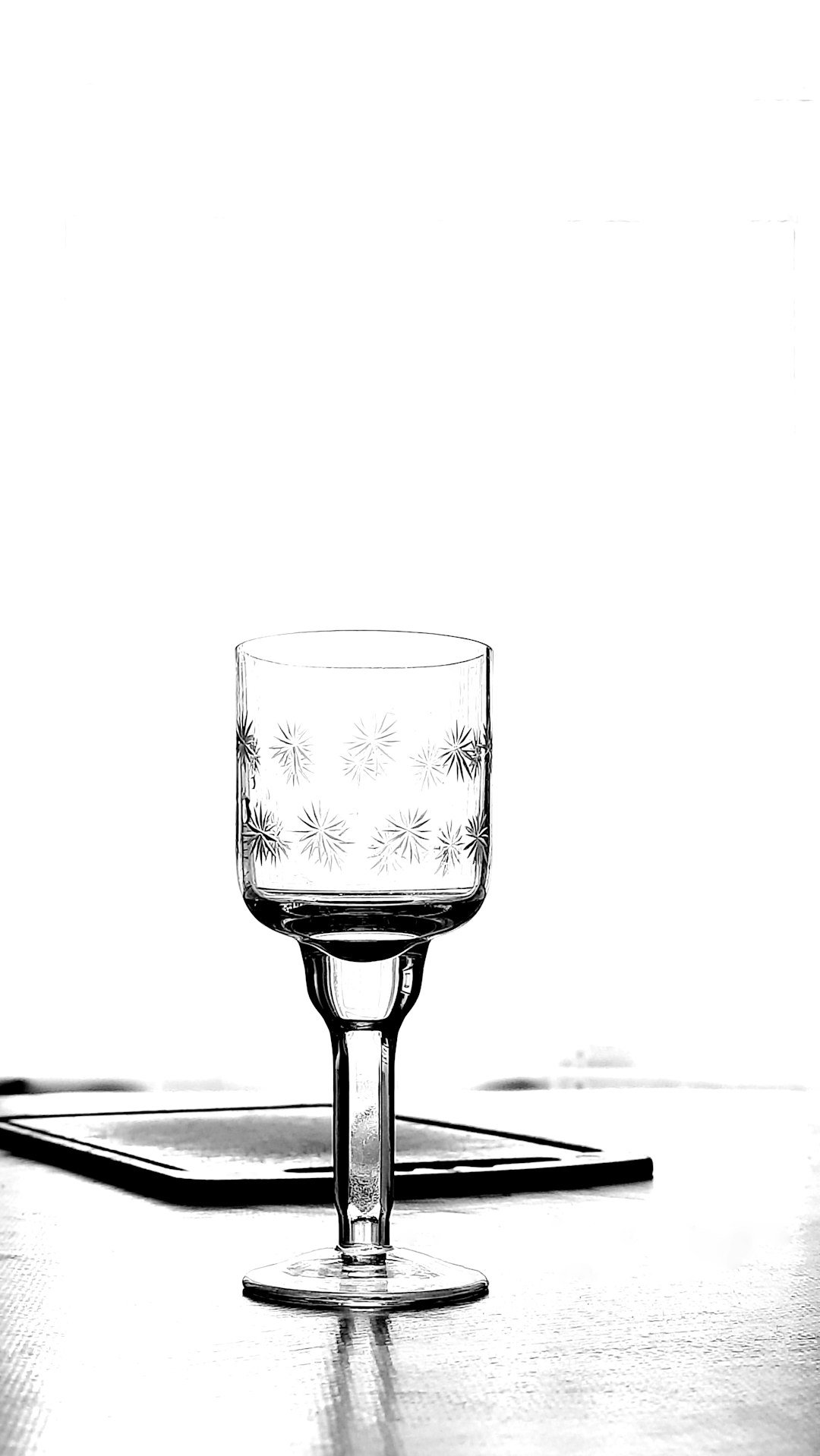 a black and white photo of a glass on a table