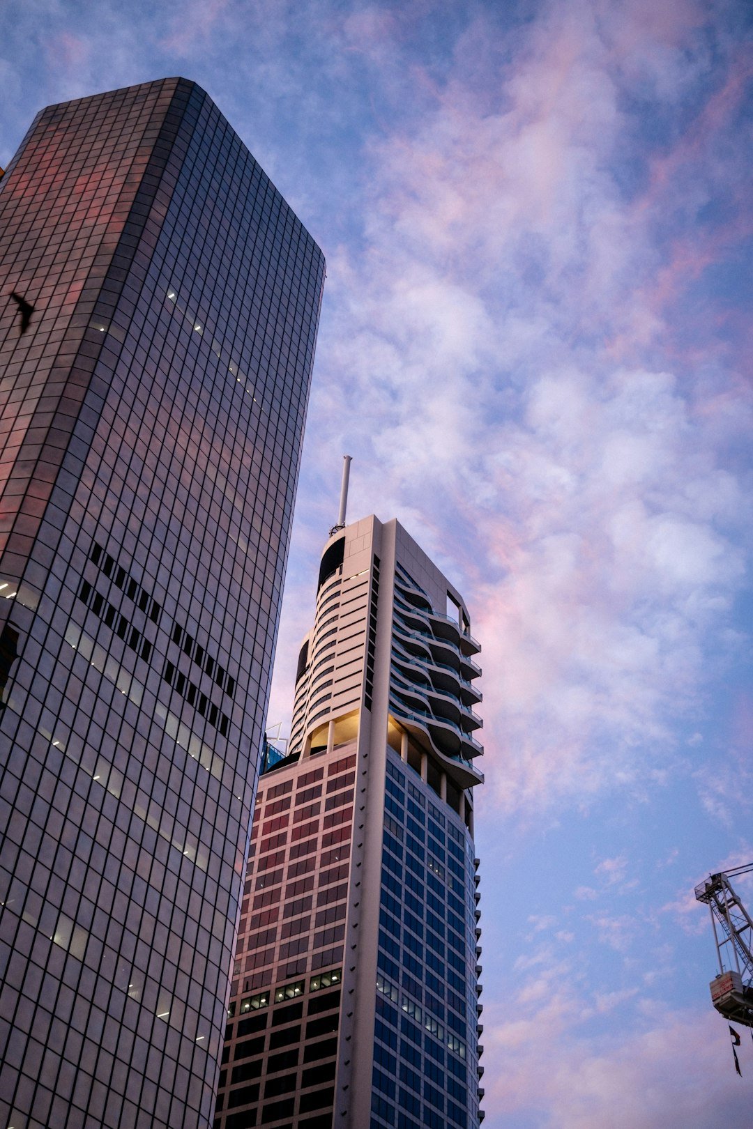 Skyscrapers tower under a colorful, cloudy sky.