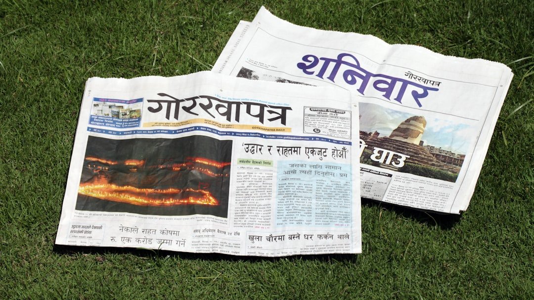 A newspaper laying on top of a lush green field