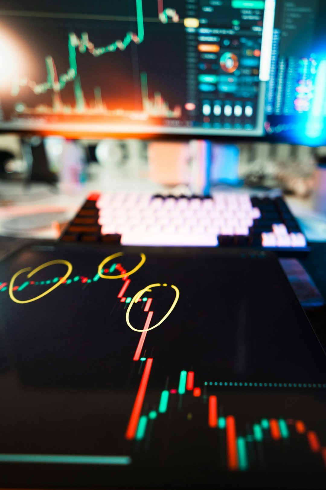 Stock market charts are displayed on digital devices.