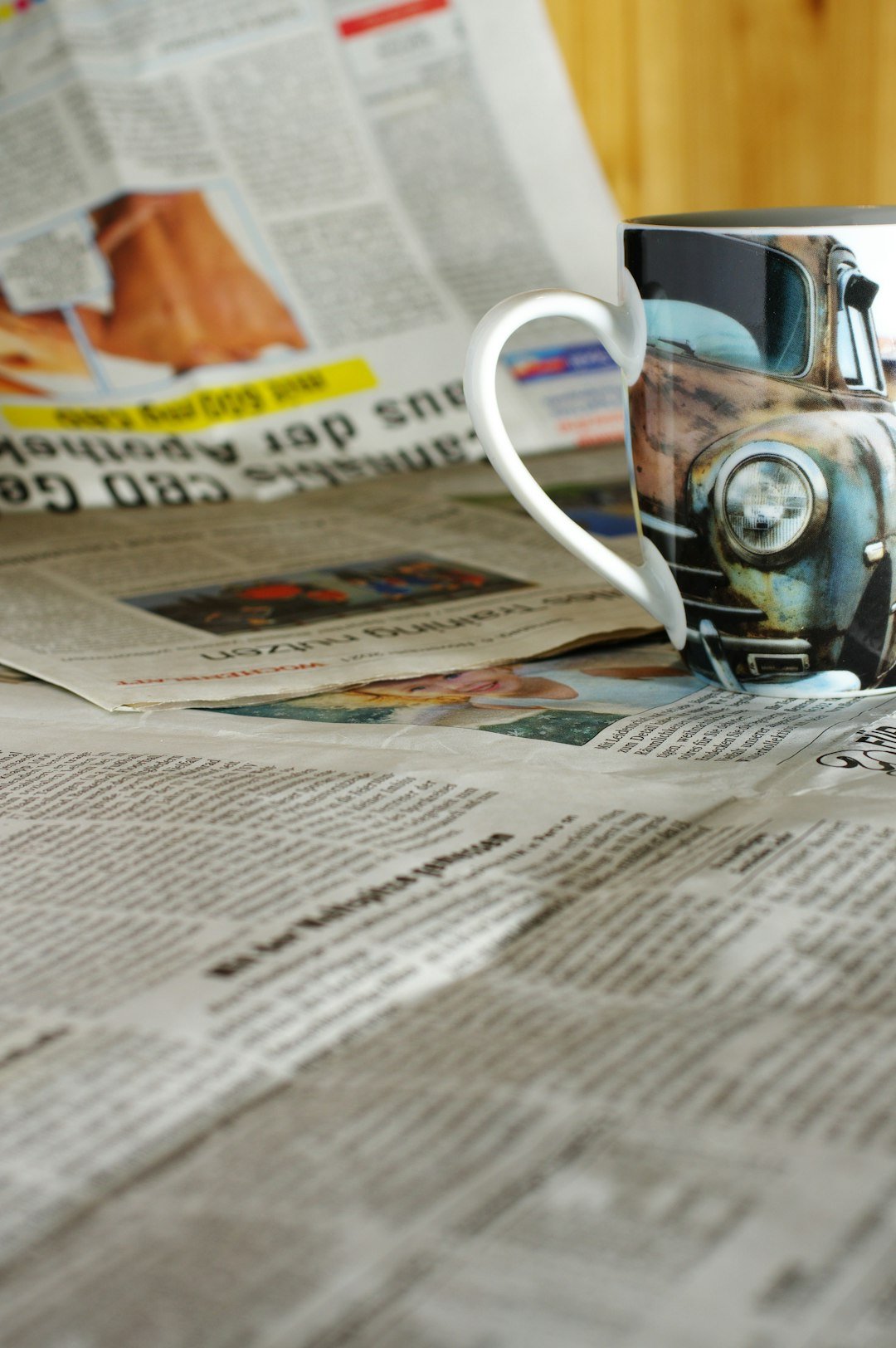 a coffee cup sitting on top of a newspaper