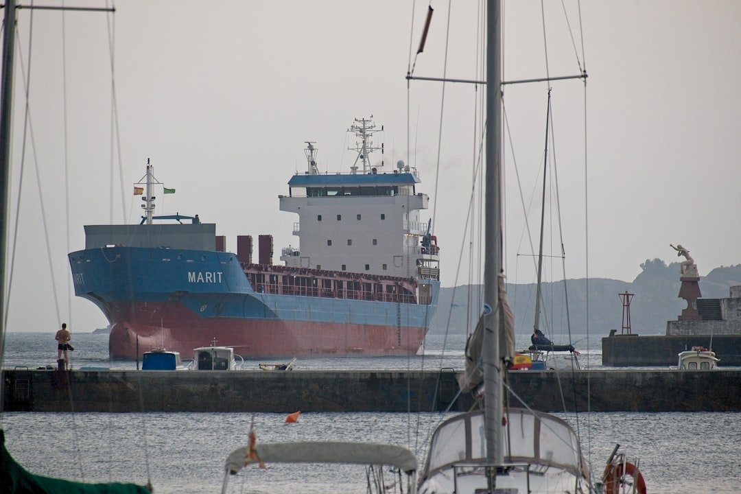 Large cargo ship sails into a harbor.