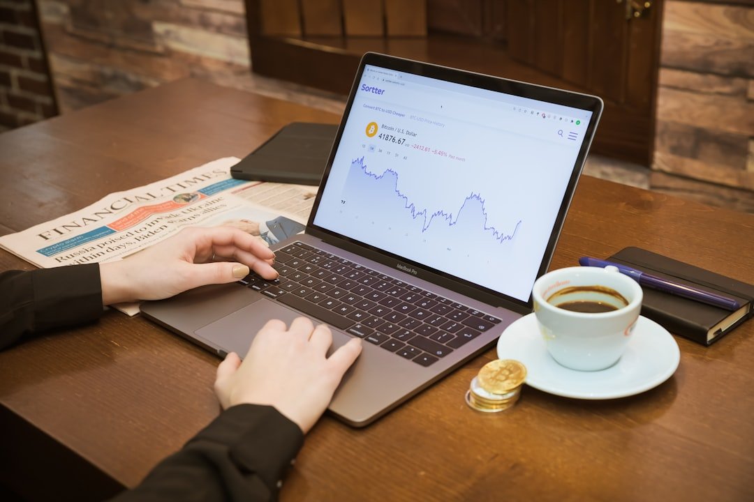 a person using a laptop on a table with a cup of coffee