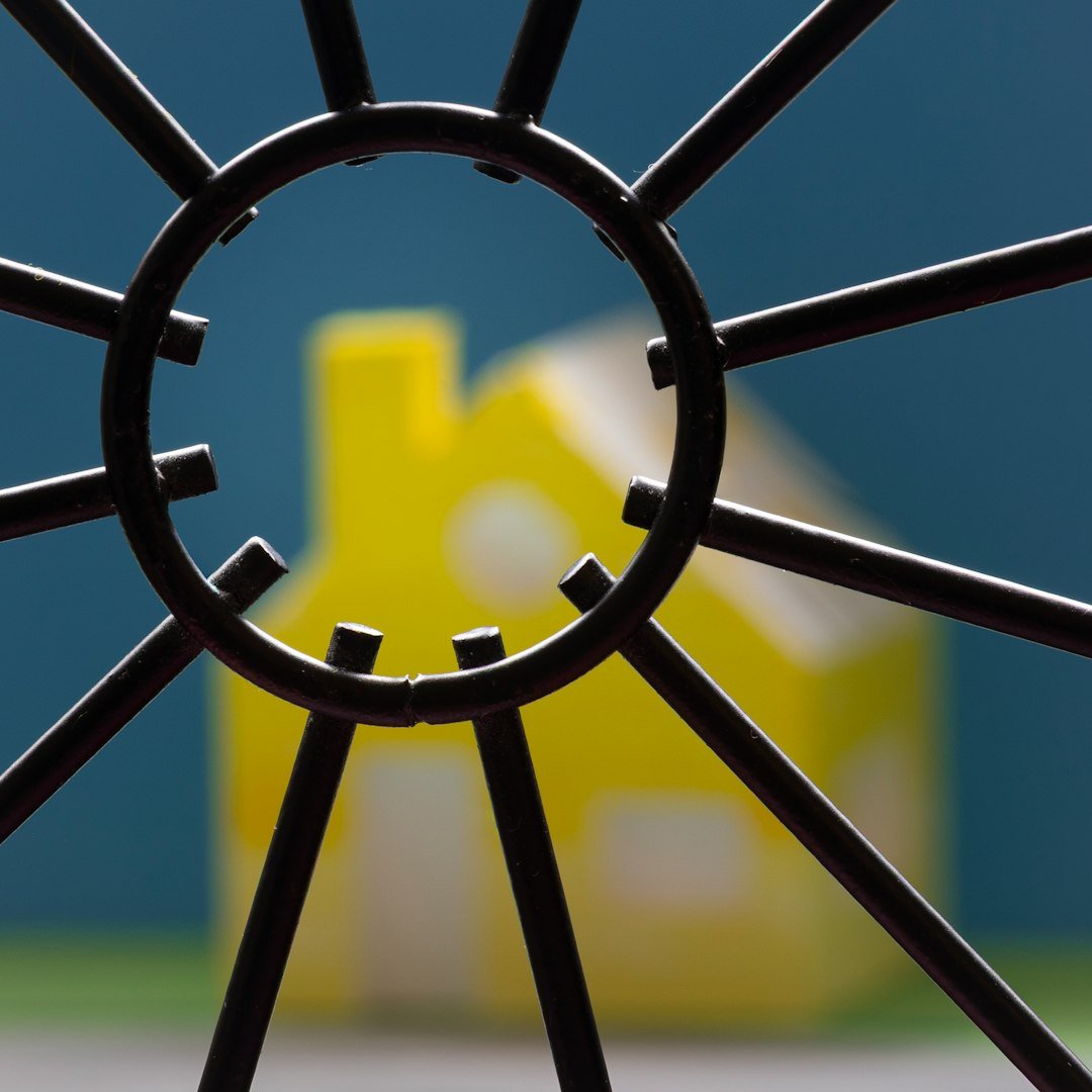 Yellow toy house seen through metal grate