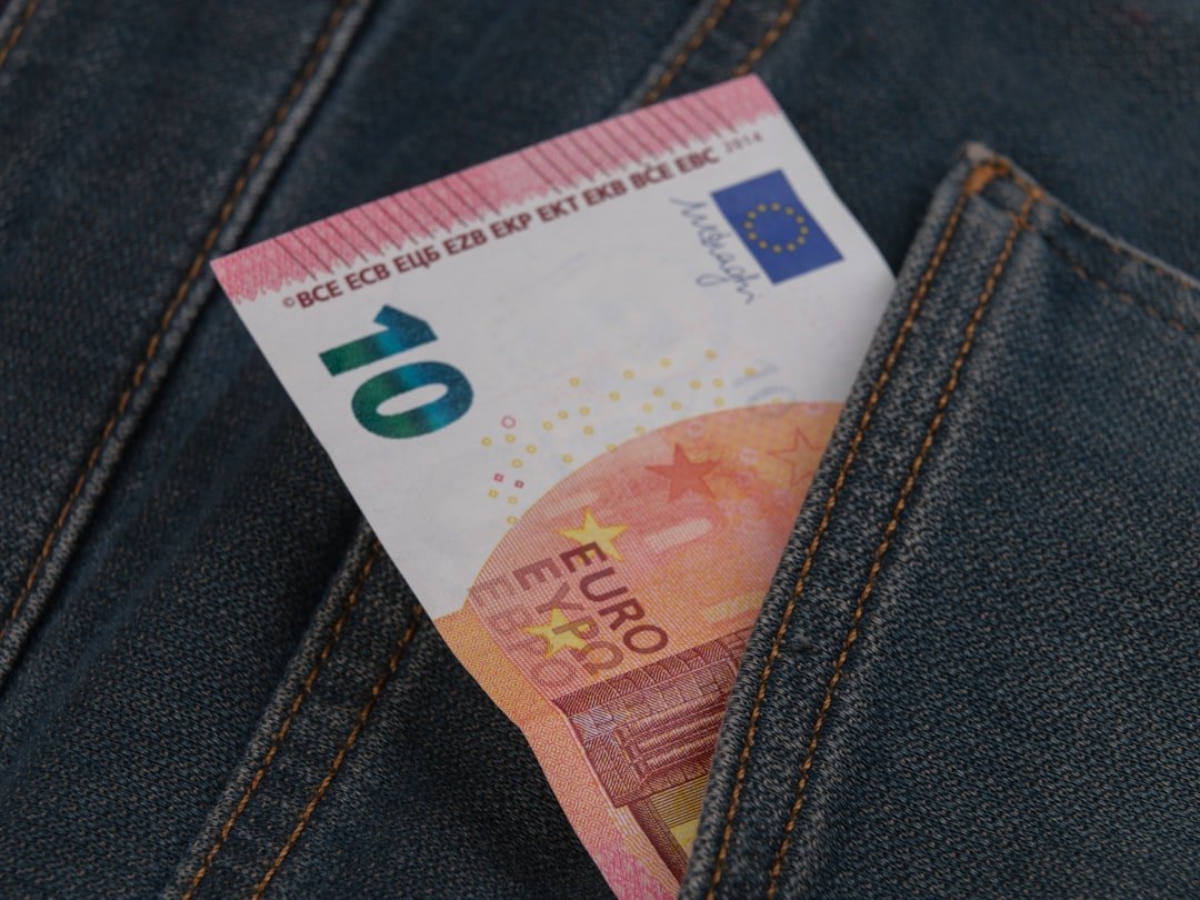 a money bill sticking out of the back pocket of a pair of jeans
