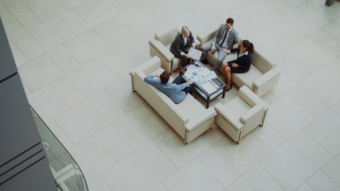 Business people meeting on sofas in a modern lobby.