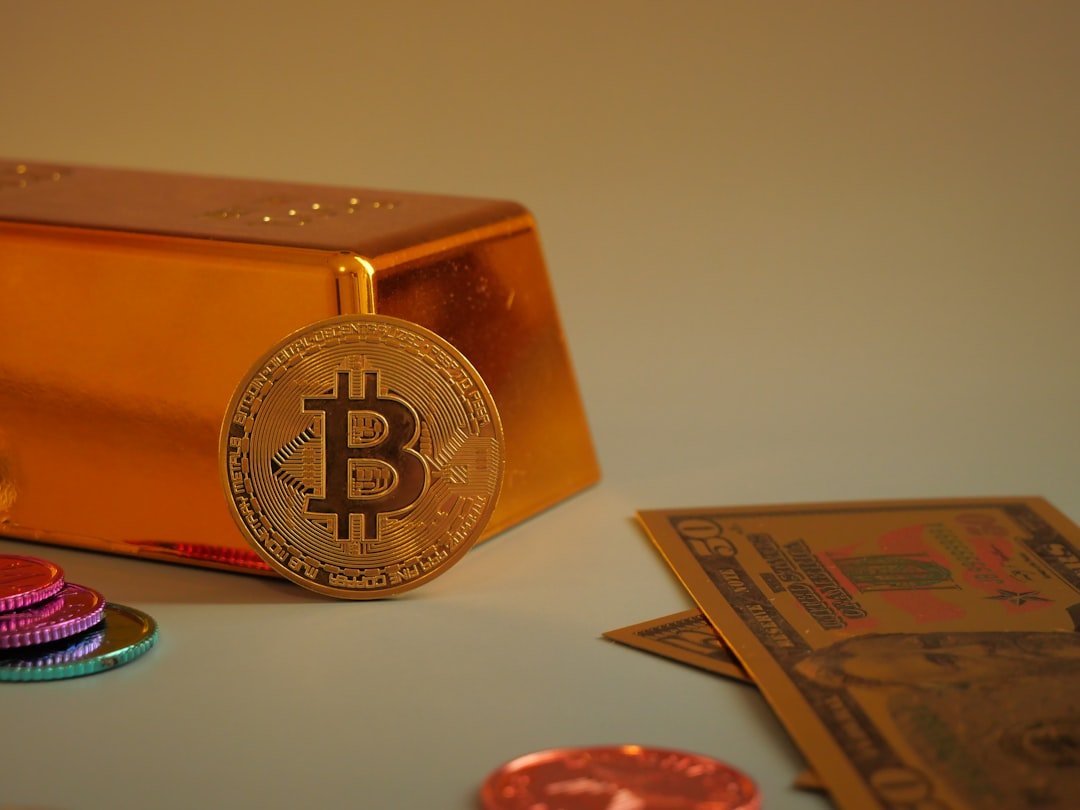 Bitcoin coin with gold bar and currency notes.