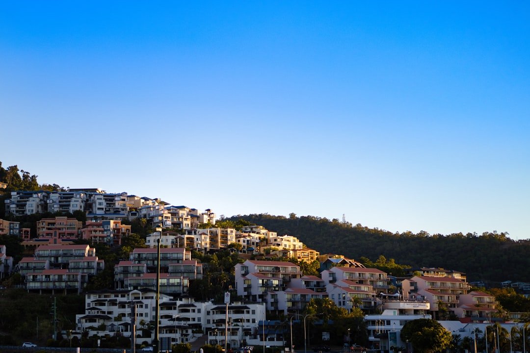 Houses on a hillside under a clear blue sky.