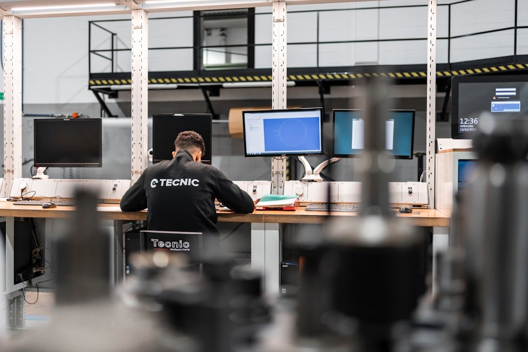 A worker is concentrating at multiple computer screens.
