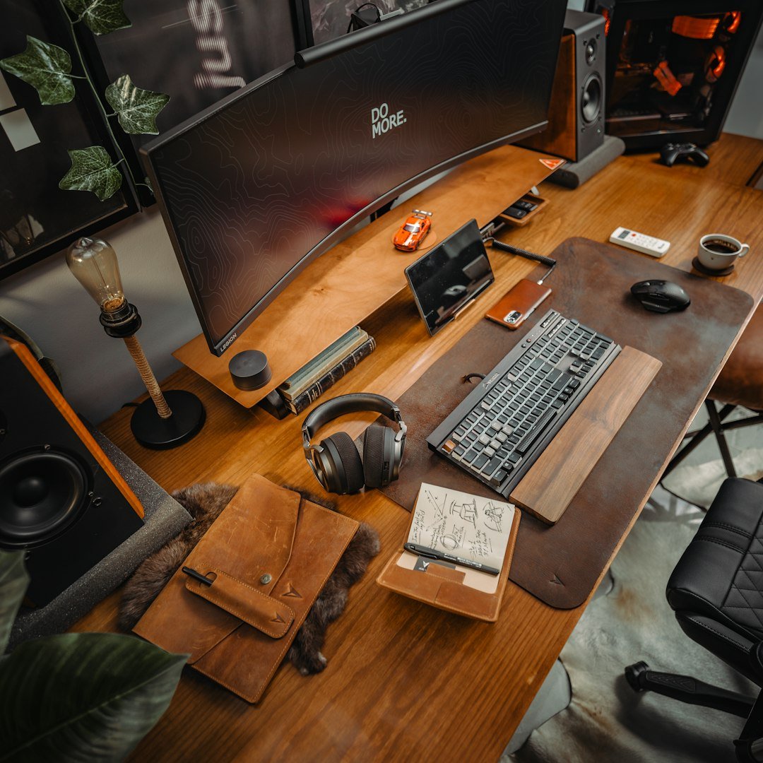 A wooden desk topped with a computer monitor and keyboard
