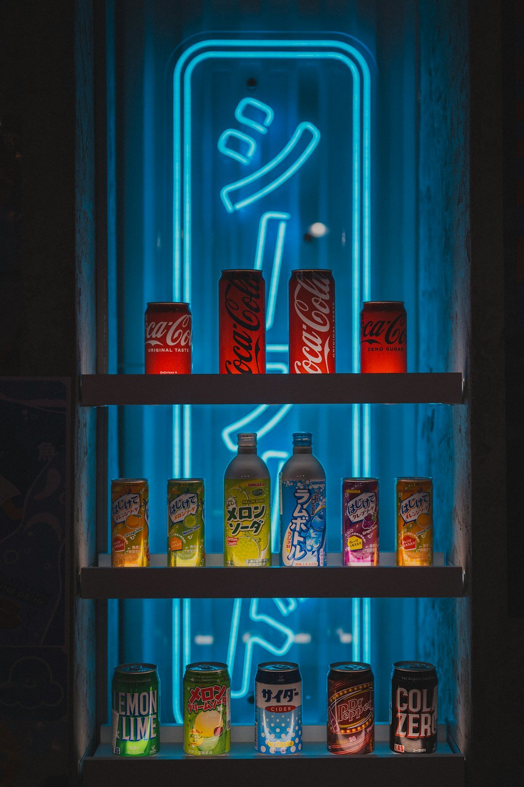 Coca-cola and soda bottles displayed with neon lighting.